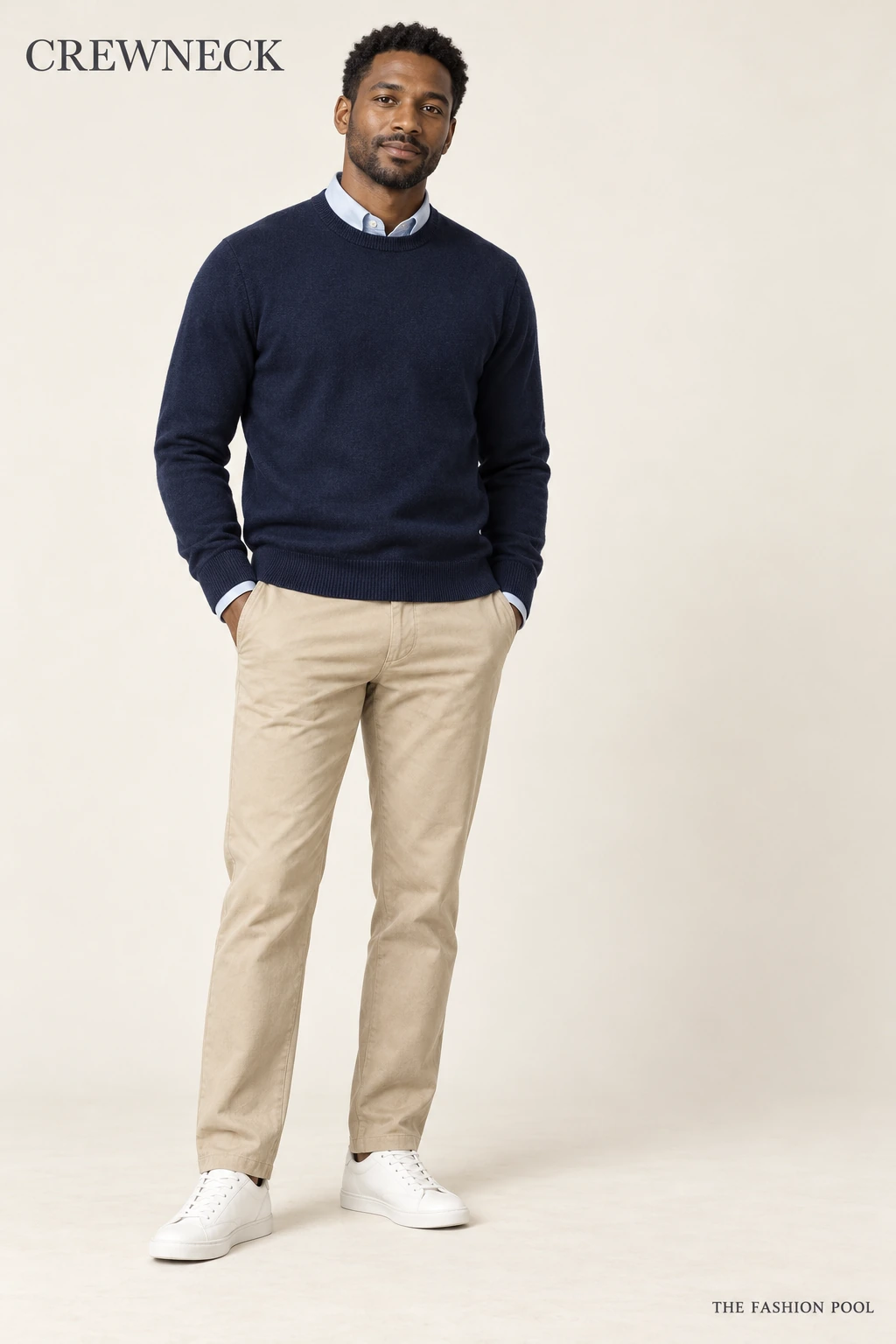 Man illustrated in a navy crewneck over a pale-blue collared shirt with the collar points under the knit edge, stone chinos and white sneakers.
