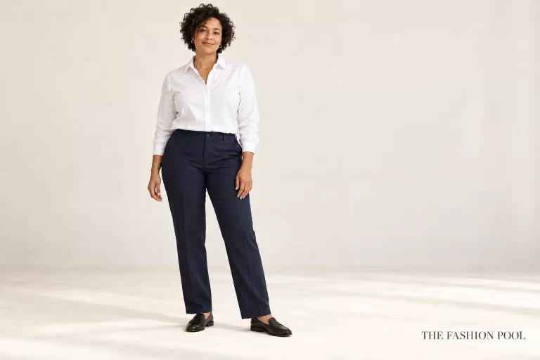 Woman wearing a comfortably buttoned white shirt with navy straight-leg trousers and black loafers.